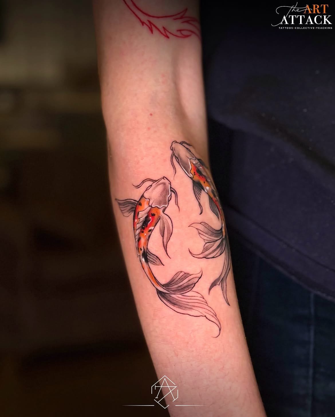 Close view of a koi fish tattoo wrapping around a forearm.