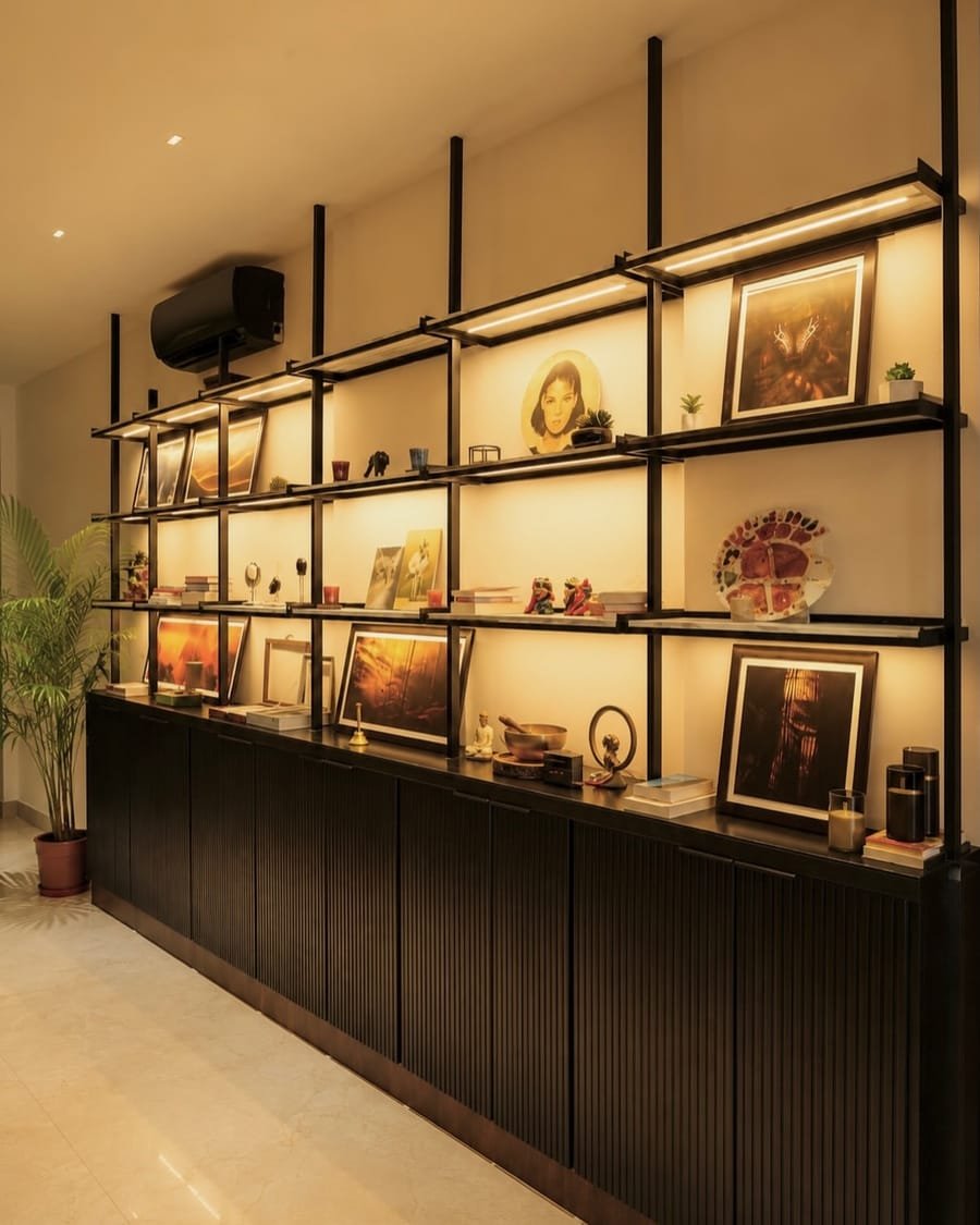 Lit display shelving inside The Art Attack, hung with framed artwork.